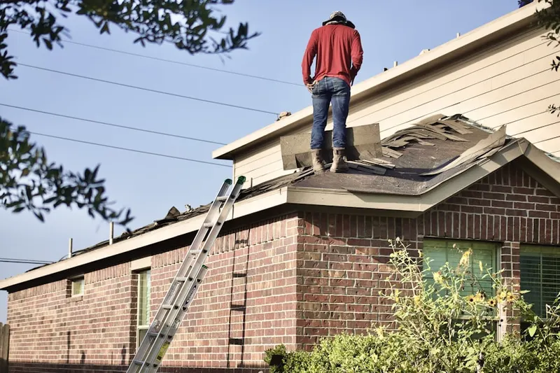 Professional roofer working on a residential roof in Zachary